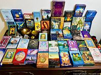 Full spread of tarot and oracle deck boxes arrayed on table