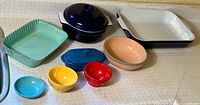 Photo showing collection of stoneware dishes with various colors and sizes including navy blue Emile Henry casserole and baking dishes.