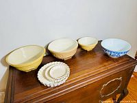 Overview of all mixing bowls and tart pans on wooden surface showing seven total items.