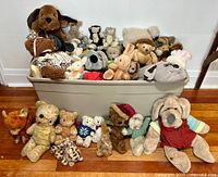 Wide view of bin overflowing with assorted vintage and contemporary stuffed plush animals arranged in and in front of bin showing variety