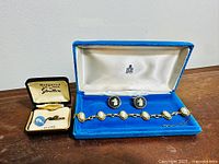 Full view of the Wedgwood jewelry set showing bracelet and earrings in Birks blue velvet box and tie tac in Stratton box