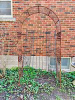 Front view of wrought iron garden arbour with three trellis panels behind