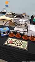 Overall lot: espresso machine, 4 cup & saucer sets, metal sign, emoji mug