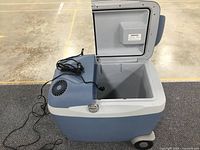 Open lid showing spacious interior compartment and power vents on cooler lid.