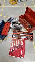Tools including circular saw, socket set, two metal tool boxes filled with wrenches and other hand tools, fabric pouch with wrenches.