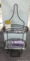 Black metal wall-mount shower rack with items including lavender soap