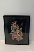 Full view of the framed Asian needlepoint portrait showing five figures in colorful traditional clothing.