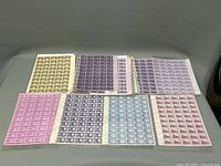 Photo showing 8 sheets of vintage block postage stamps, featuring various colors and denominations.