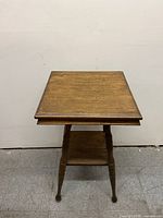 Front angled view of the wooden candle stand/end table showing rectangular top and lower shelf.