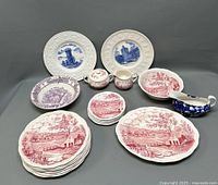 Full overview of all transferware pieces showing plates, bowls, sugar bowl, creamer, and gravy boat in various blue, red, and purple scenic patterns.