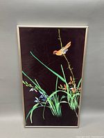 Front view of watercolor painting showing bird on fabric with plants against dark background framed