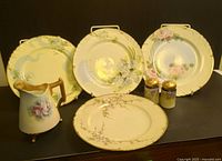 Lot overview with 4 luncheon plates, 1 pitcher, and salt & pepper shakers arranged on black background.