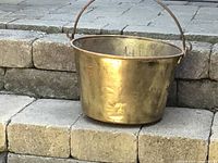 Full view of the antique brass jelly pan showing its overall shape, color, and handle.