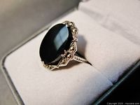 Close-up front angle of the Art Deco ring showing the large black oval stone and marcasite details on the silver frame with visible prong setting and ring band.