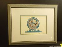 Full view of the framed art piece showing the print mounted with a light wood frame and white matting.