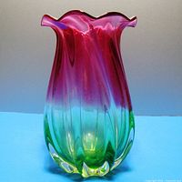 Front view of blown glass vase showing pink top and green base with ruffled edges