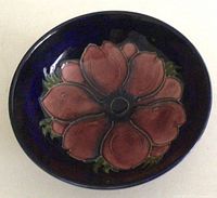 Top view showing central pink rose flower motif with navy blue background inside the bowl.