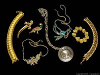 Overview of all eight pieces in the lot including bracelets, necklaces, and brooches.