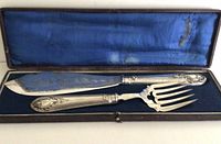 Fish serving knife and fork in original fitted box with blue satin interior lining showing wear
