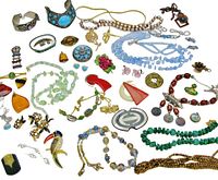 Full view of assorted vintage costume jewelry laid out with a variety of necklaces, bracelets, brooches, and earrings.