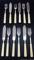Full set of 6 forks and 6 knives laid out showing matching handles and knife blade engravings