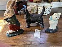 All three cast iron doorstops on floor: rabbit, schnauzer, cat with tag in front
