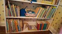 Full view of two and a half shelves filled with children's books in various sizes and colors, with notable series grouped together.
