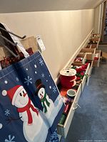 Image showing drawers with various Christmas wrapping supplies including spools of ribbon, gift bags, and holiday cards