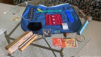 View of all items on glass table including blue occupational apron, energy chime, game pieces, and kaleidoscope.