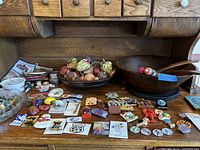 Wide view of the assortment laid out showing magnets, wooden salad bowl, dried floral balls, and small items.
