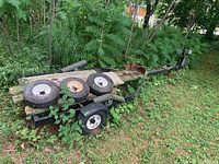 Full view of trailer with three loose wheels on deck