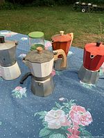 All four moka pots and grinder on table