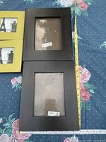 Front view two black frames and tape for scale