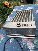 Front and top view showing eight rollers, control panel, missing knob