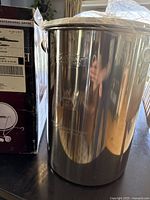 Close-up photo of the large stainless steel cooking pot with Outdoor Gourmet logo and professional grade etching.