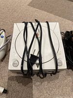 Sega Dreamcast video game console top front view with cables coiled over the unit.