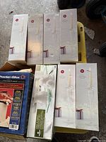 Photo showing six boxed glass taper candle holders upright, white boxes with candle image and red gift graphic.