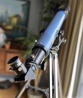 Close-up of the telescope's eyepiece and lens assembly, showing the angled design and focus knobs