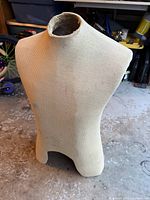 Full view of the vintage Taylor's fabric-covered torso dress form showing its shape and surface wear