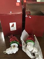 Two cardinal bird night lights with textured red glass and green bases alongside their original red boxes.