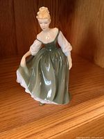Side view of the Royal Doulton Pretty Lady figurine depicting a woman in green dress with puffed sleeves.