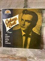 Front cover of Johnny Cash album titled 'The Songs That Made Him Famous' showing young Johnny Cash portrait and text.