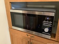 Front view of Panasonic microwave oven showing door closed and control panel with digital display and dial.