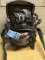 Minolta Dynax 500si camera with lens mounted inside the Lowepro carrying case, showing the camera setup and case interior.