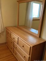 Full view of oak dresser showing six drawers and large mirror positioned on top, wood grain and finish clearly visible.