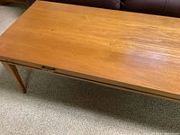Top view of long wooden coffee table showing smooth wood grain surface.