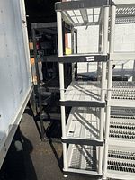 Side and angled view of the 5 tier plastic shelving unit outdoors showing height and structure.