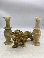 Two alabaster marble vases with alabaster marble lion figurine arranged together, on white background