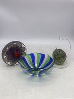 Full view of all three items: paperweight, swirl bowl, and hanging glass ball on clear stand.