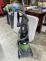 Front full view of Bissell DeepClean Premier Pet carpet cleaner showing main body, hose, and cleaning attachment.